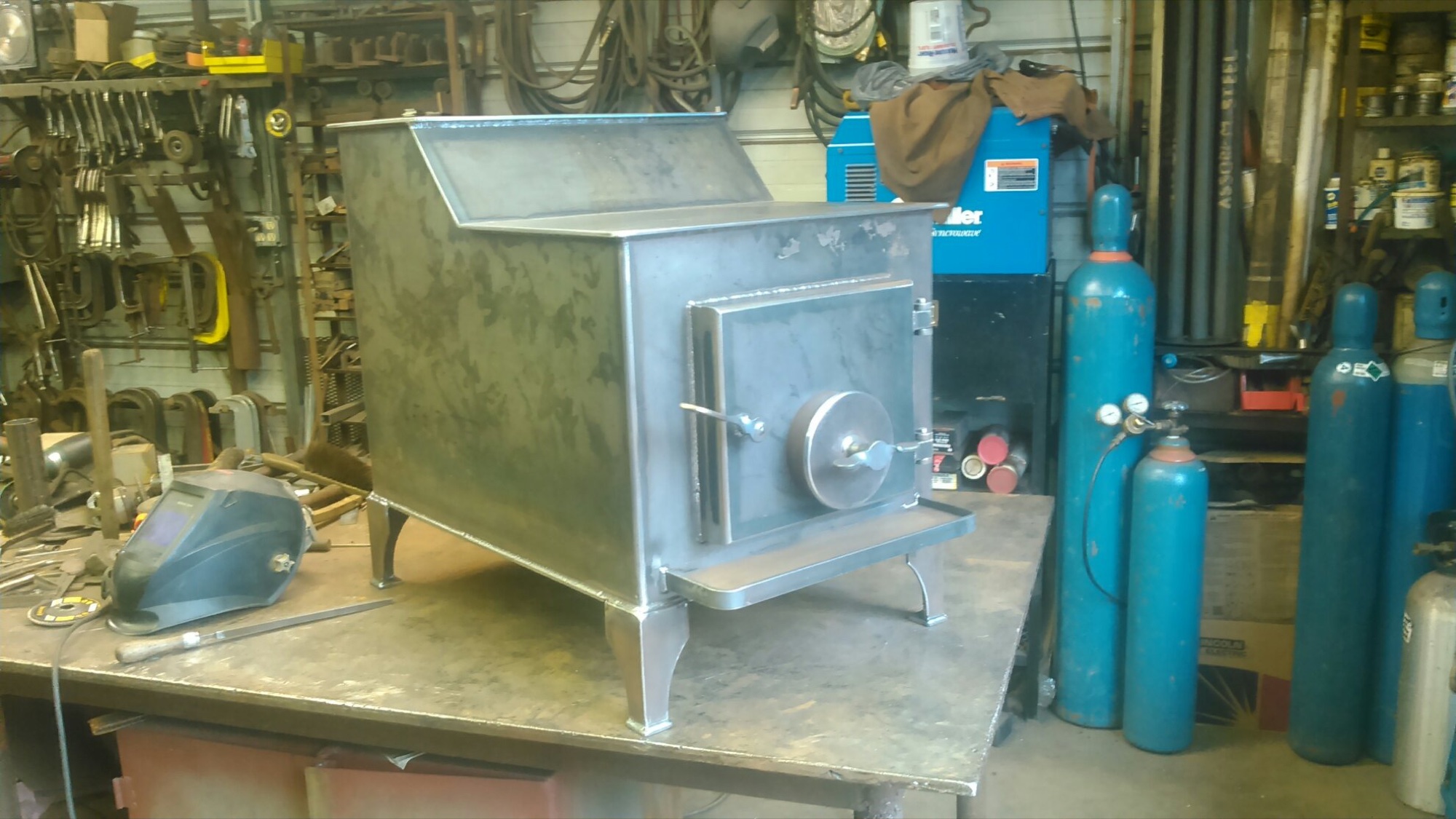 Bare-metal Ursus wood stove mid-fabrication in the shop