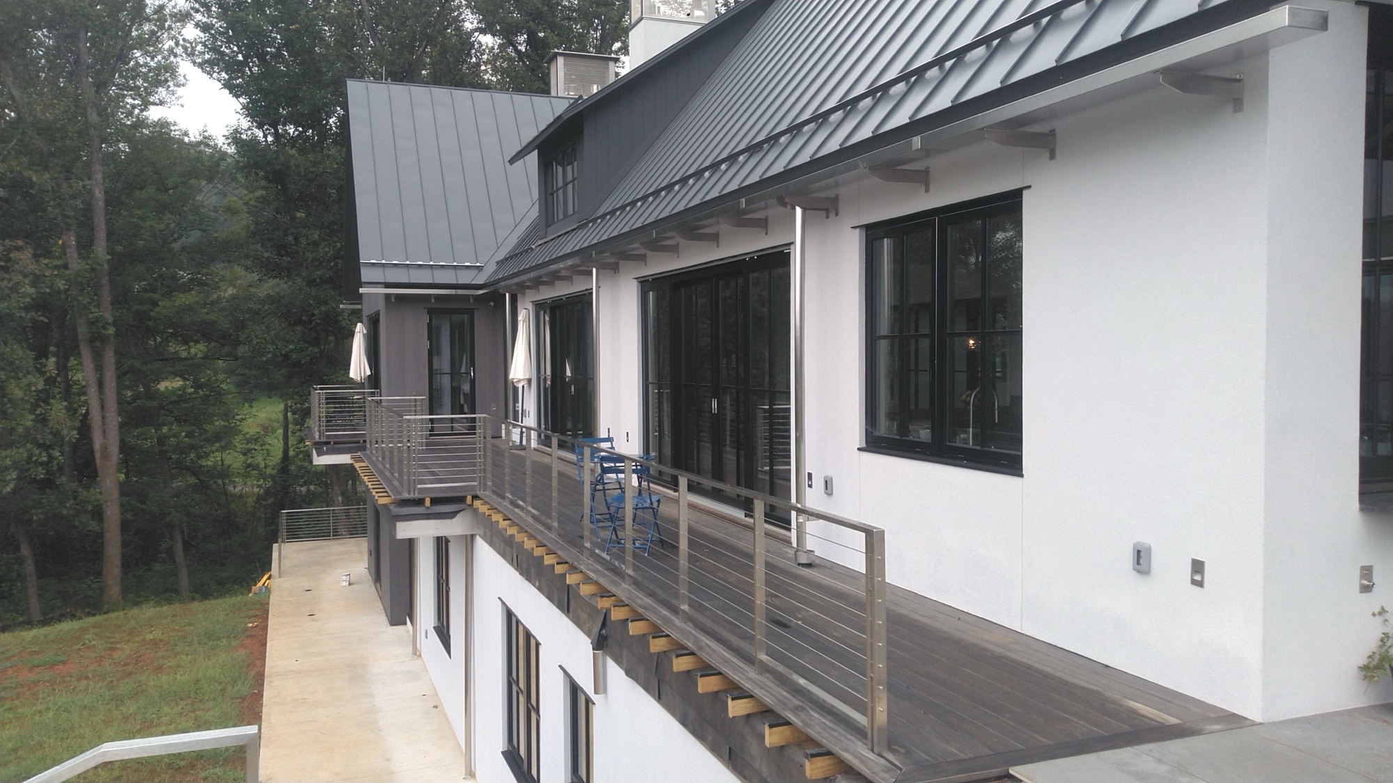 First-floor deck with brushed stainless cable railings on the modern farmhouse