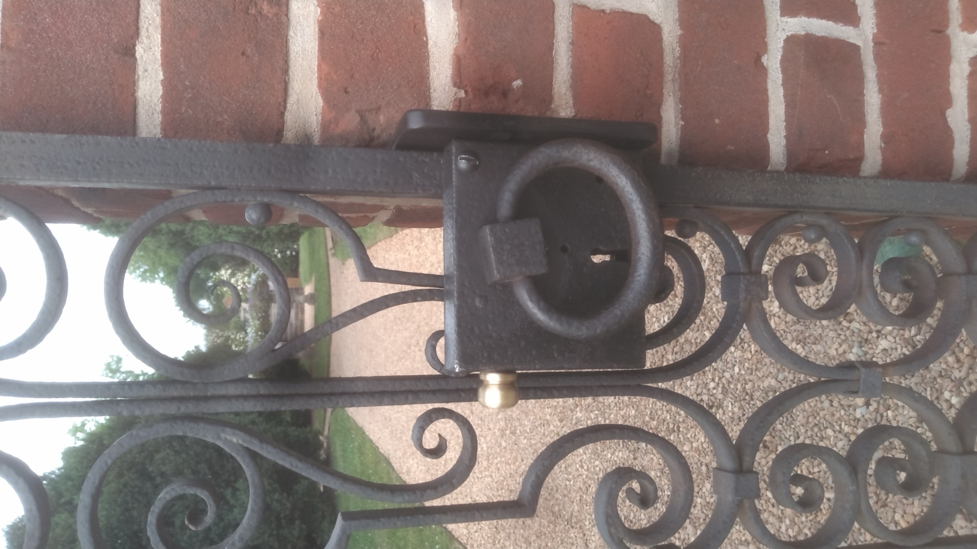 Detail of the custom ring-latch mechanism on the restored scrollwork gate